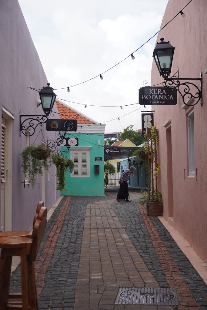 Colorful alley in Willemstad with vibrant walls and street signs, capturing Curaçao's charm.