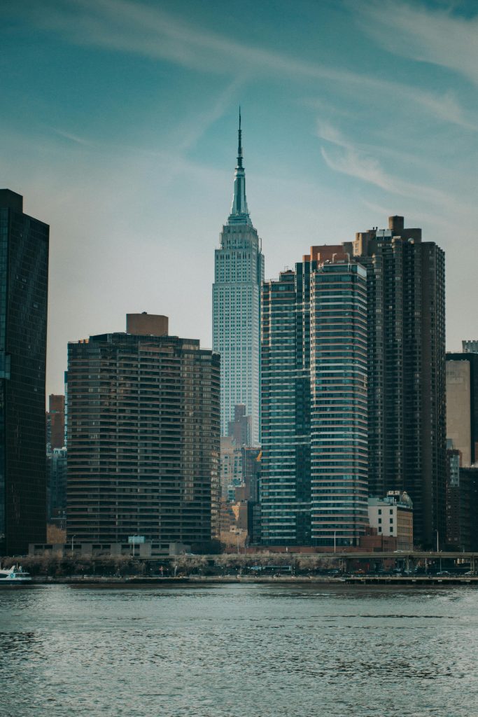 Iconic view of the New York City skyline with the Empire State Building rising behind modern skyscrapers.