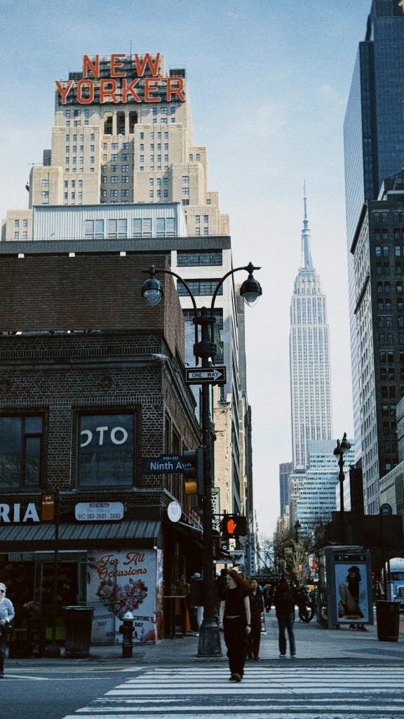 Dynamic street view of New York City featuring the New Yorker and Empire State Buildings.